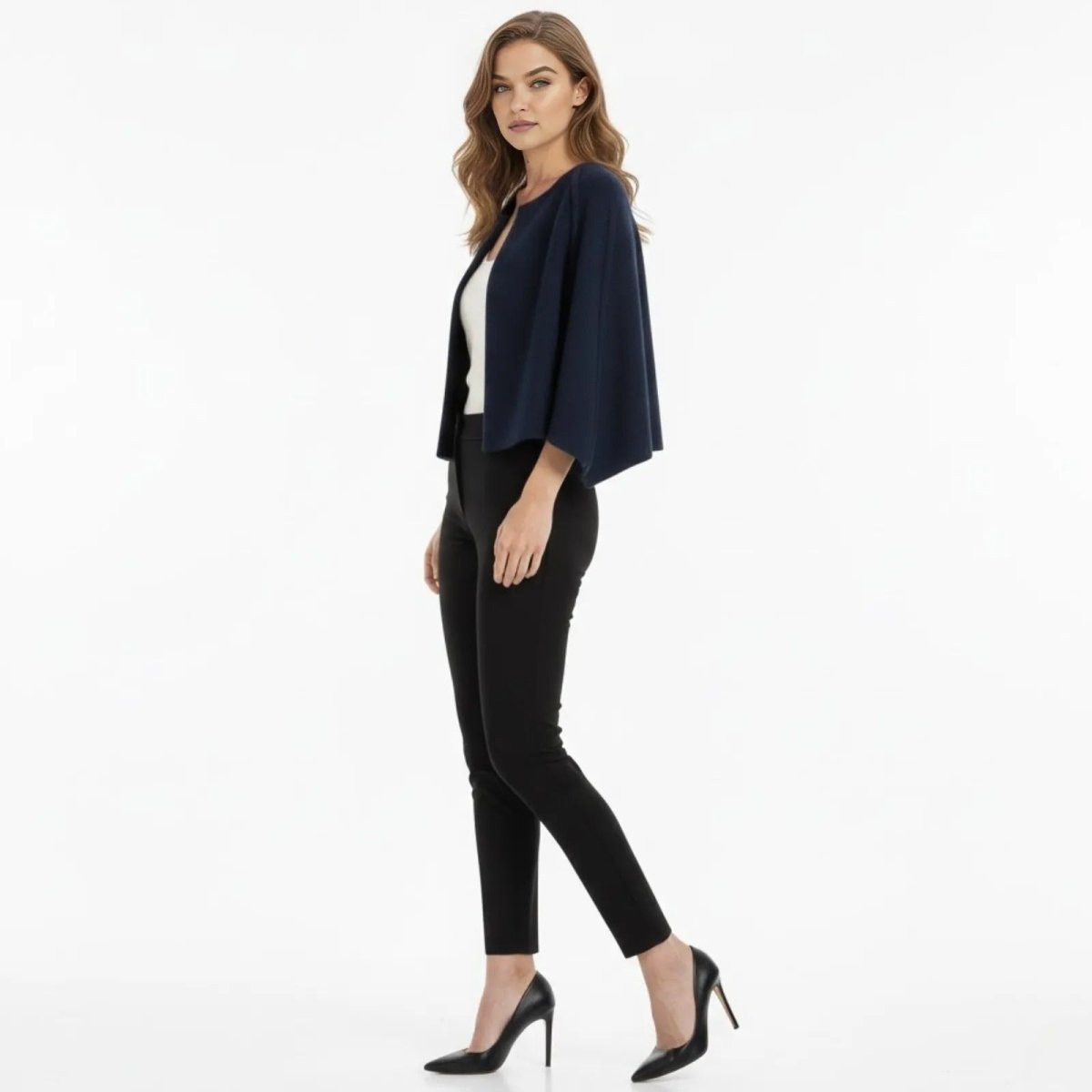 Side profile of a woman in the Kouvr Laverne blue cape jacket showing the elegant drape and cropped silhouette.