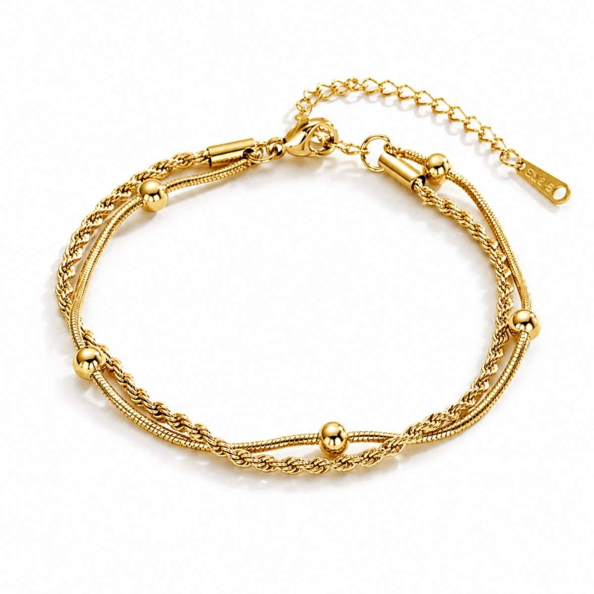 A gold layered anklet with a rope and beaded snake chain on a white studio background.