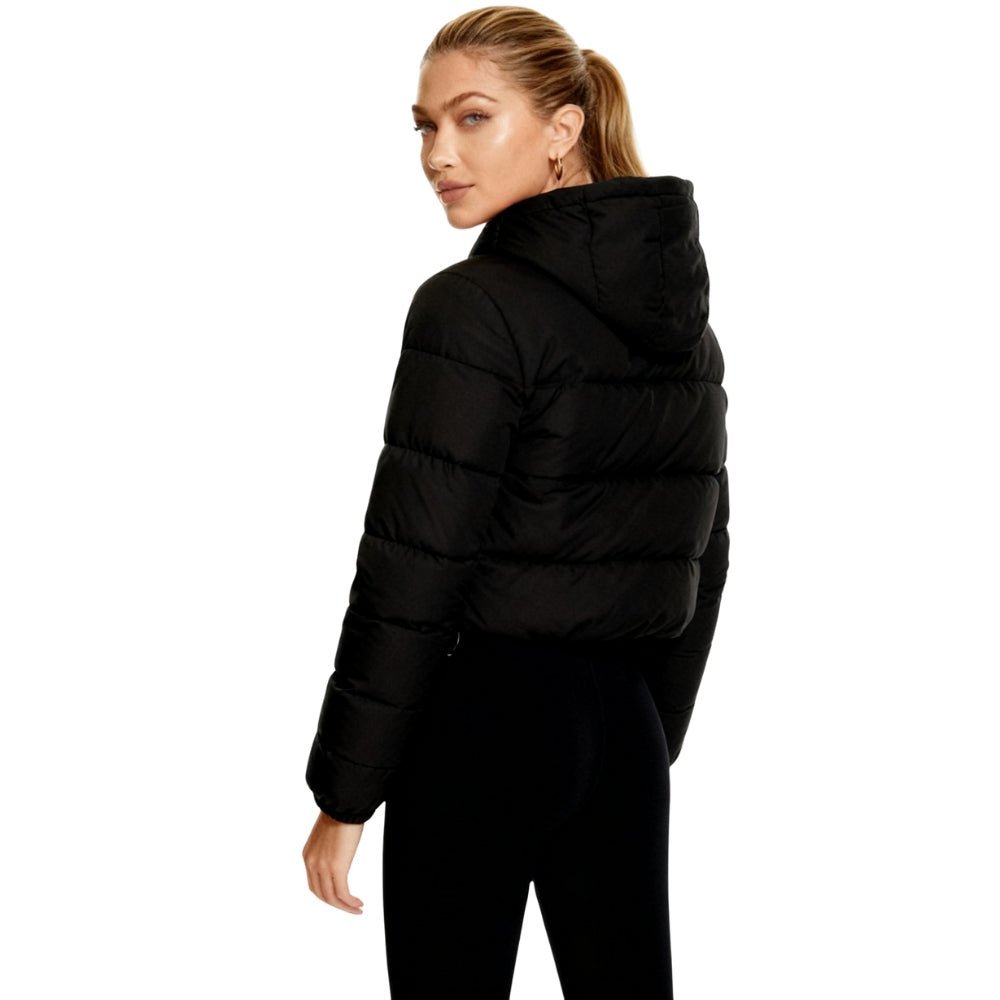 Person wearing a black Kouvr puffer jacket on a white background