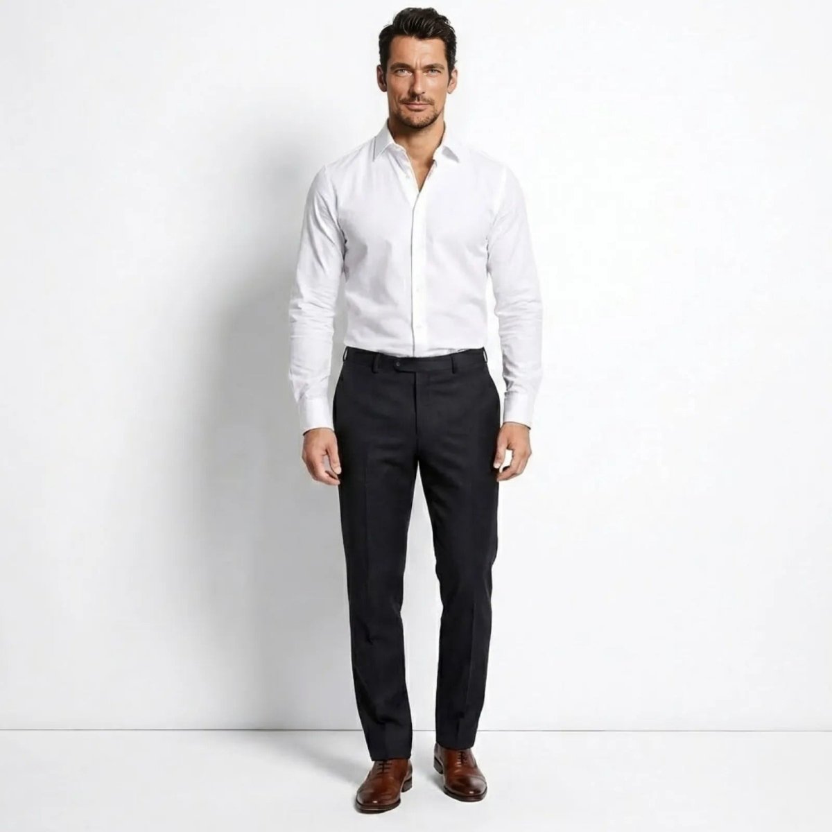 Male model wearing the Kouvr Leland White Dress Shirt in a slim fit, paired with dark trousers, viewed from the front.