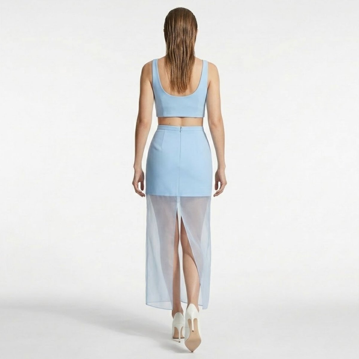 Back view of a light blue maxi skirt highlighting the invisible zipper closure, form-fitting upper panel, and dramatic sheer back slit detail.