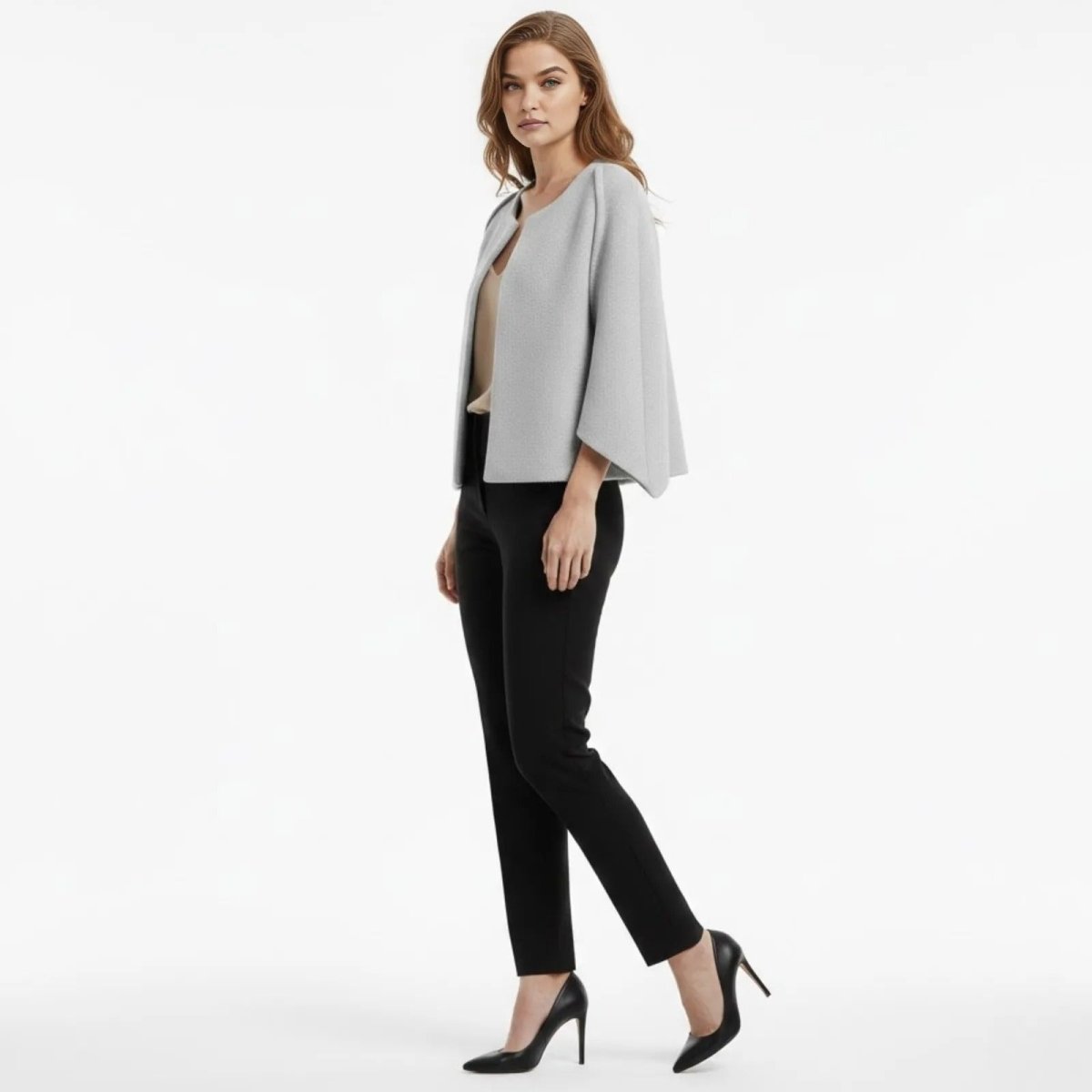 Side profile of a model wearing the Kouvr light grey cape jacket, showing the sleeve drape.