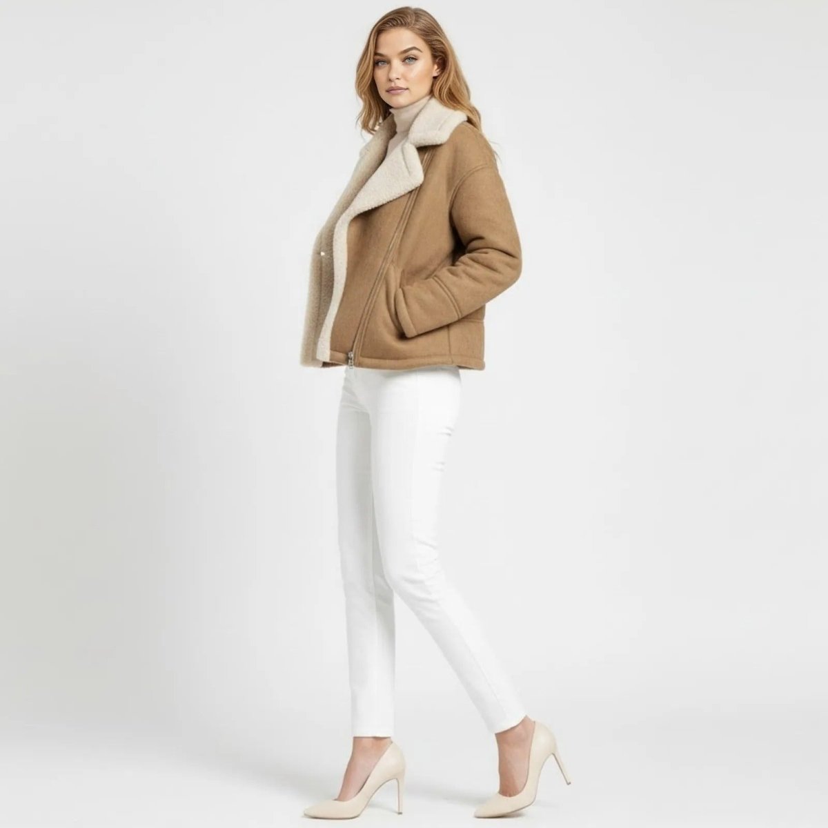 Side profile of a woman walking in the Loretta khaki faux suede biker jacket by Kouvr, showing its fit and plush shearling collar.