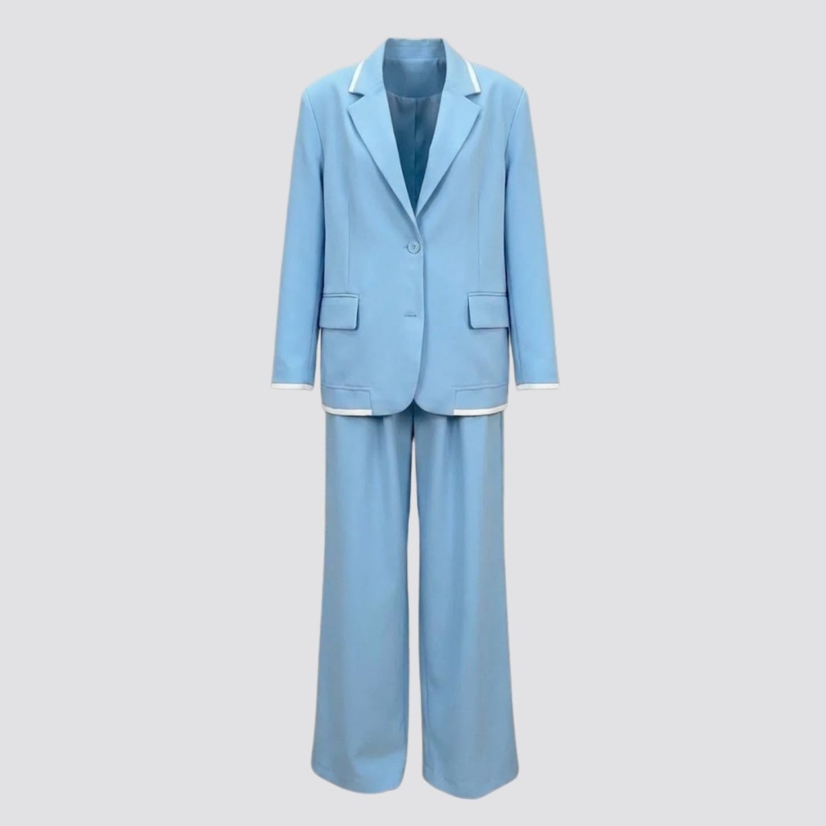 Flat lay studio shot of the Kouvr Lucia Set sky blue pant suit, displaying the front of the single-button blazer and wide-leg trousers with white piping details.