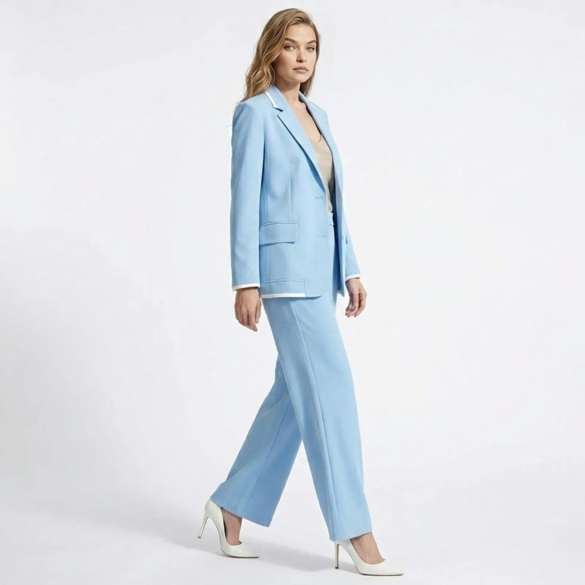 Side profile of a model walking in the Kouvr Lucia Set sky blue two-piece suit, showing the fluid movement of the wide-leg pants and the suit's tailoring.