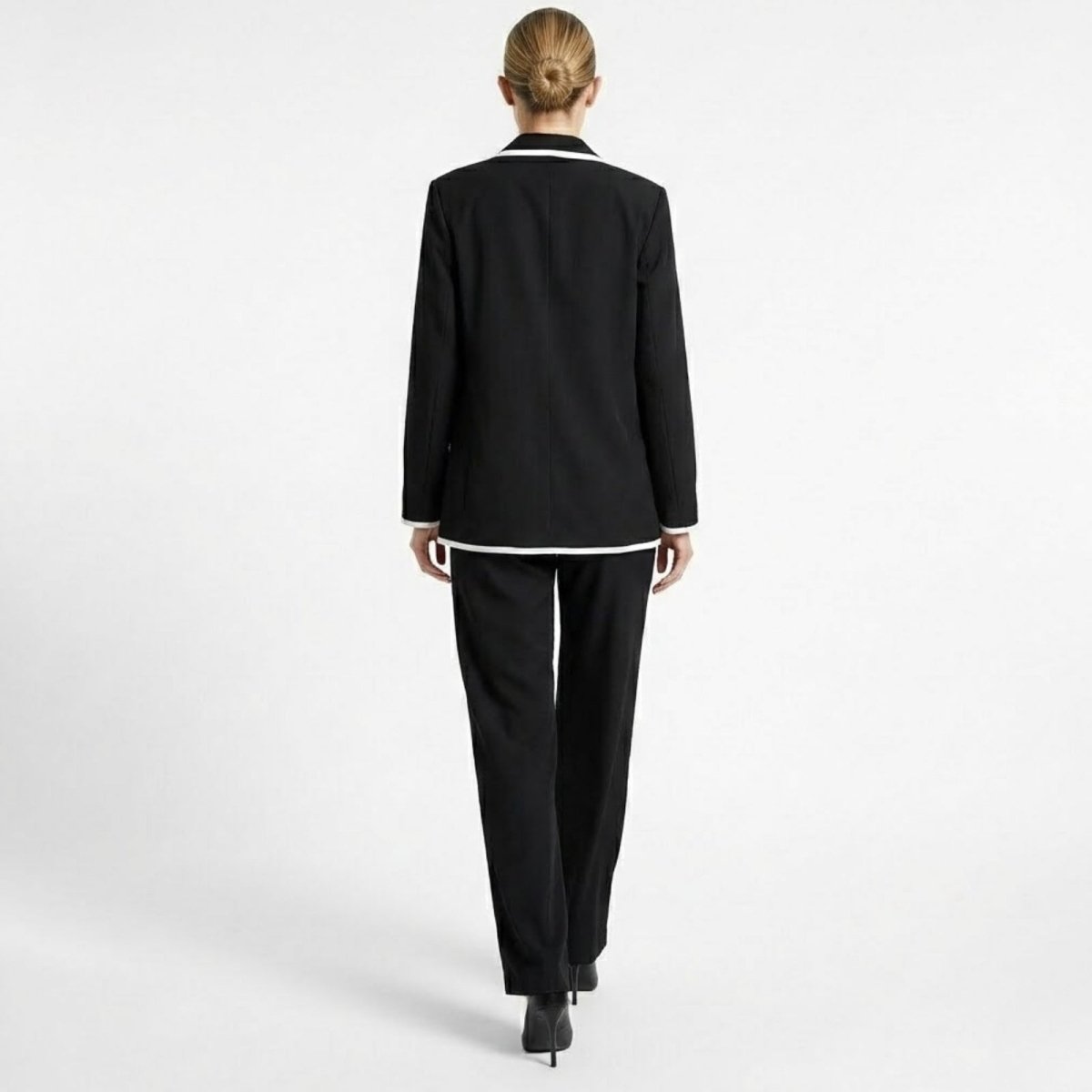 Back view of the Kouvr Lucia Power Suit, highlighting the clean lines of the single-breasted blazer and the elegant drape of the wide-leg pants.