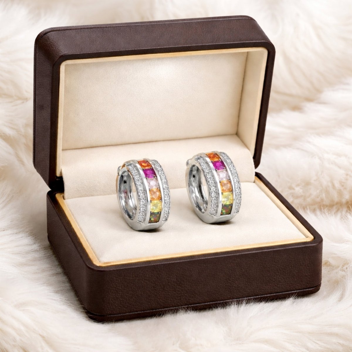 The Kouvr rainbow sapphire hoop earrings presented in a luxurious brown leather jewelry box, highlighting them as a perfect gift.