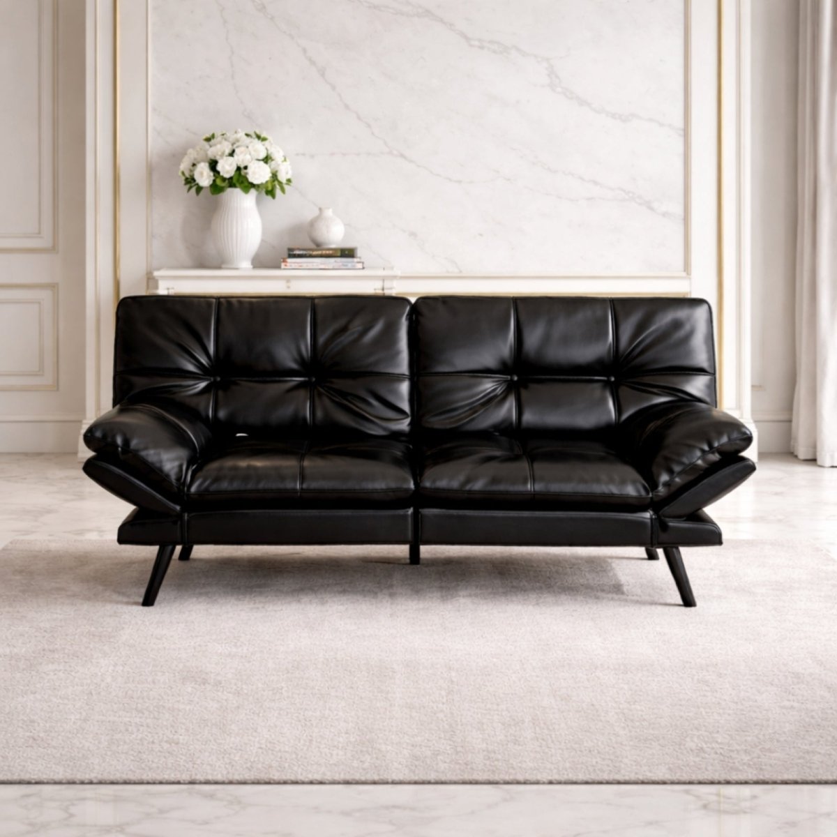 Front view of black faux leather tufted convertible sofa by Kouvr with mid-century modern metal legs in a luxury living room setting.