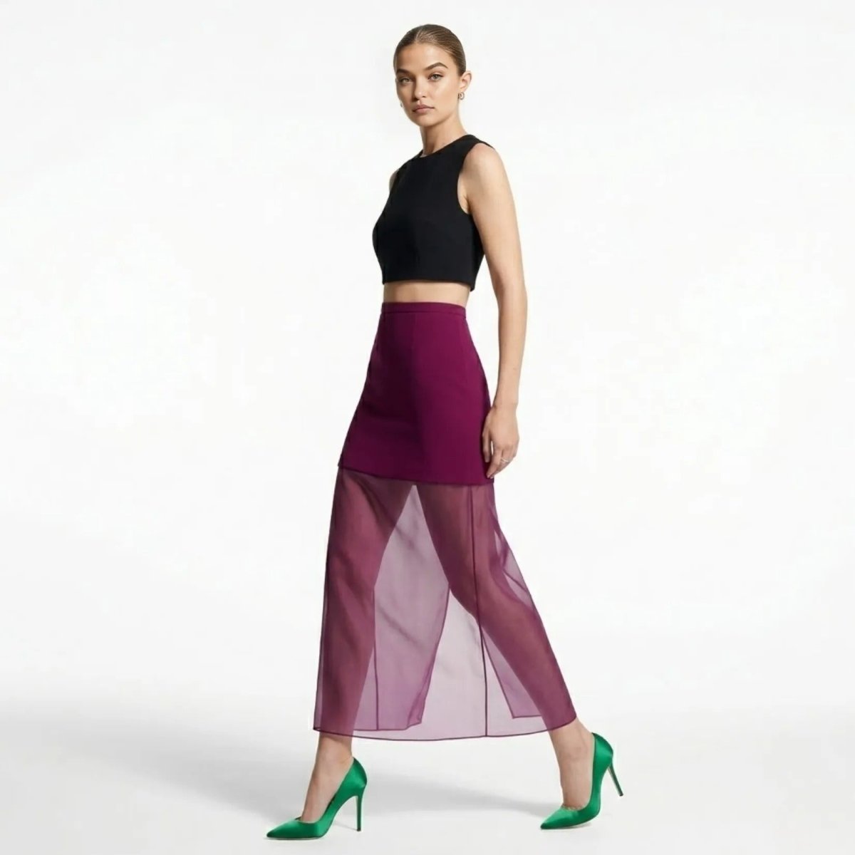 Side profile of female model walking in Kouvr magenta illusion maxi skirt showing sheer leg movement and styling.