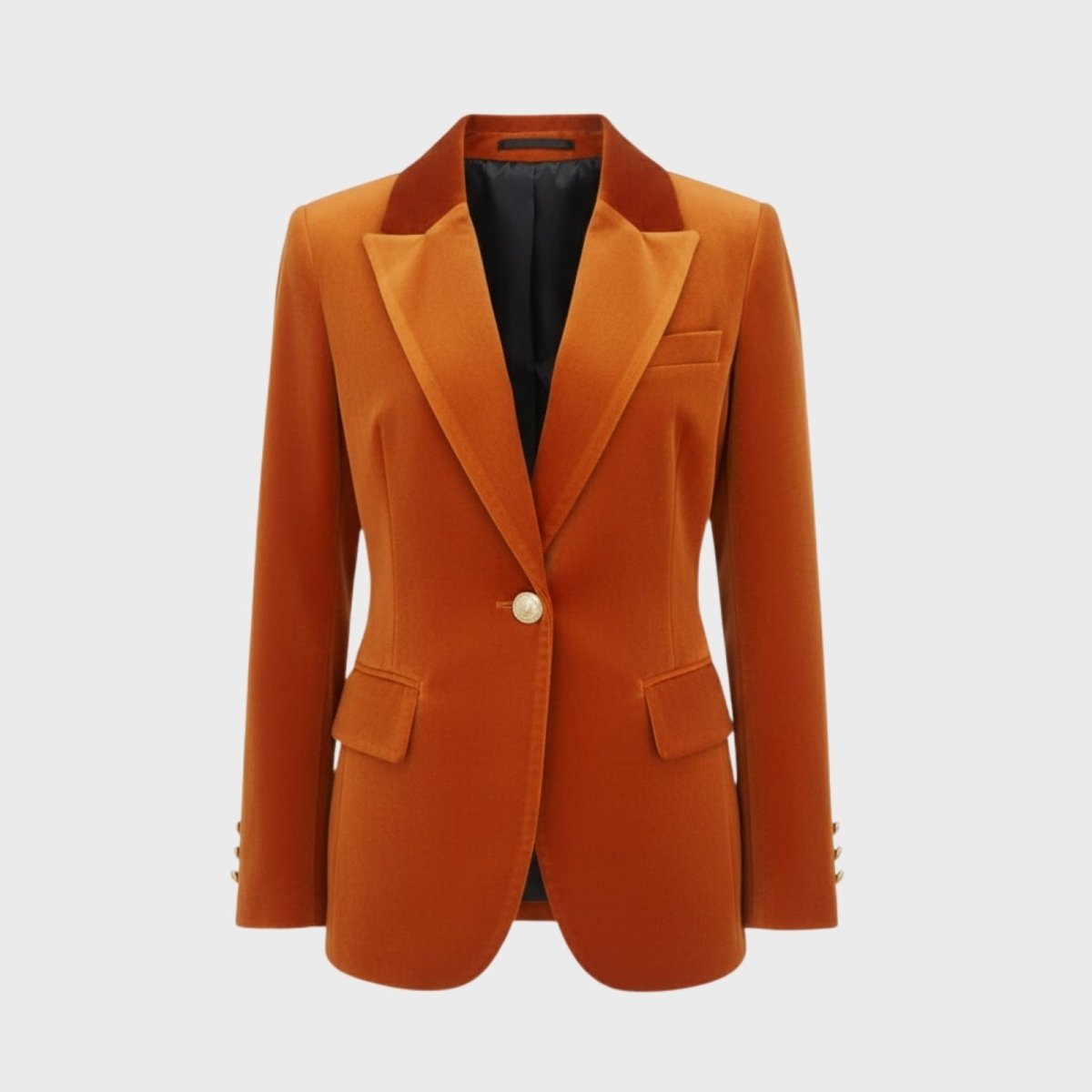 Flatlay product shot of the Kouvr Maribel single-breasted velvet blazer in rust, showcasing the peak lapels and gold-tone button.