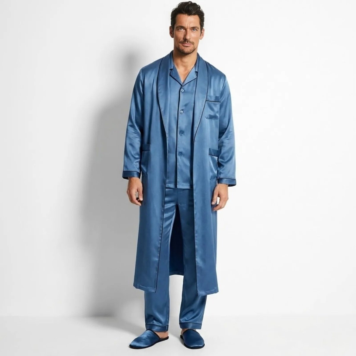 Man wearing Kouvr azure blue satin three-piece pajama set with long matching robe, front view.