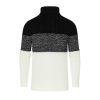 A man wearing the Kouvr color block turtleneck sweater in black, textured grey, and cream, paired with black trousers.