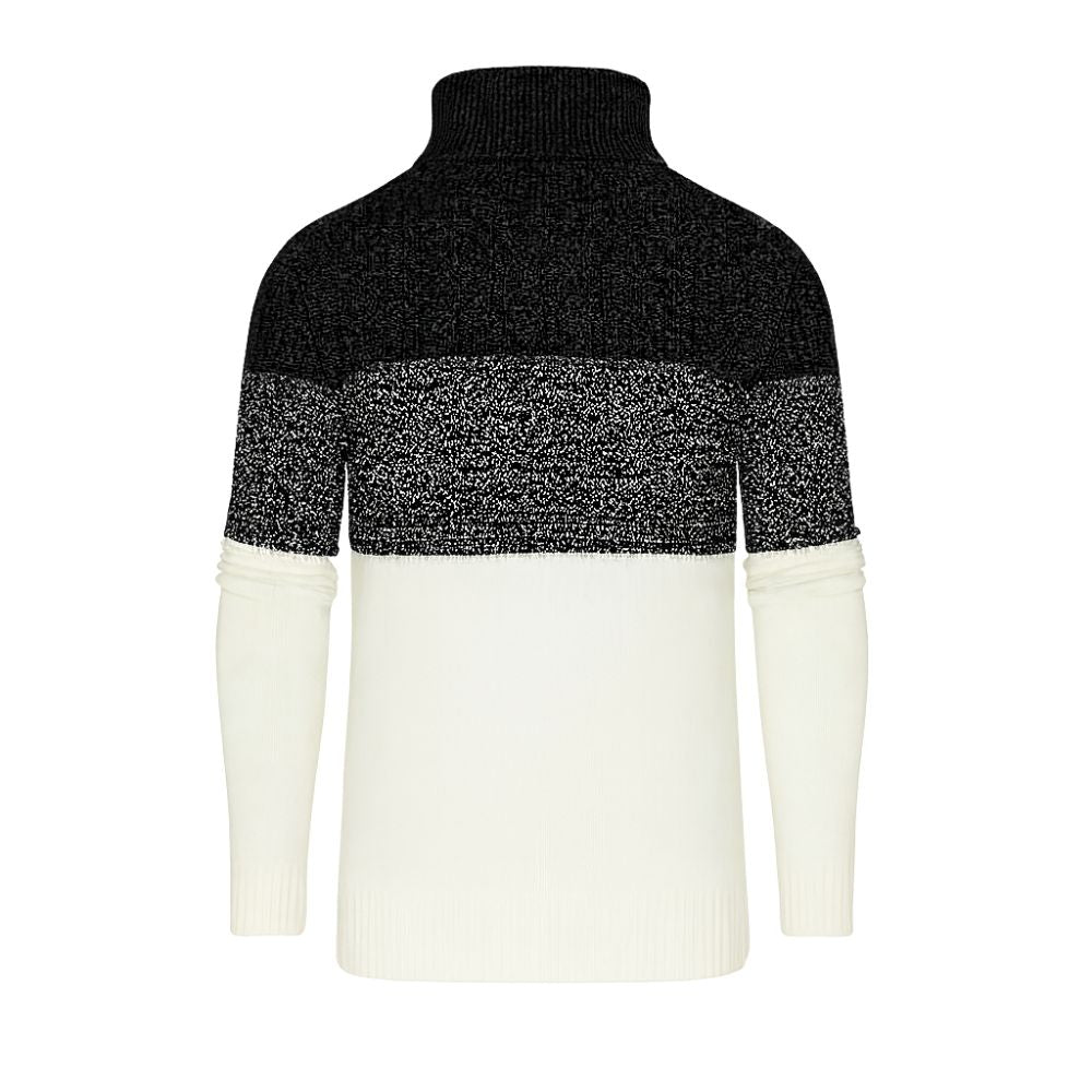 A man wearing the Kouvr color block turtleneck sweater in black, textured grey, and cream, paired with black trousers.