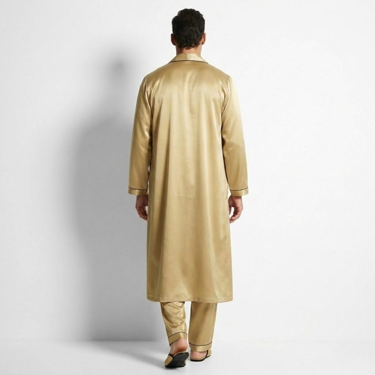 Back view of a male model wearing the Kouvr gold satin long robe over matching pajama trousers, showcasing the classic, clean design.