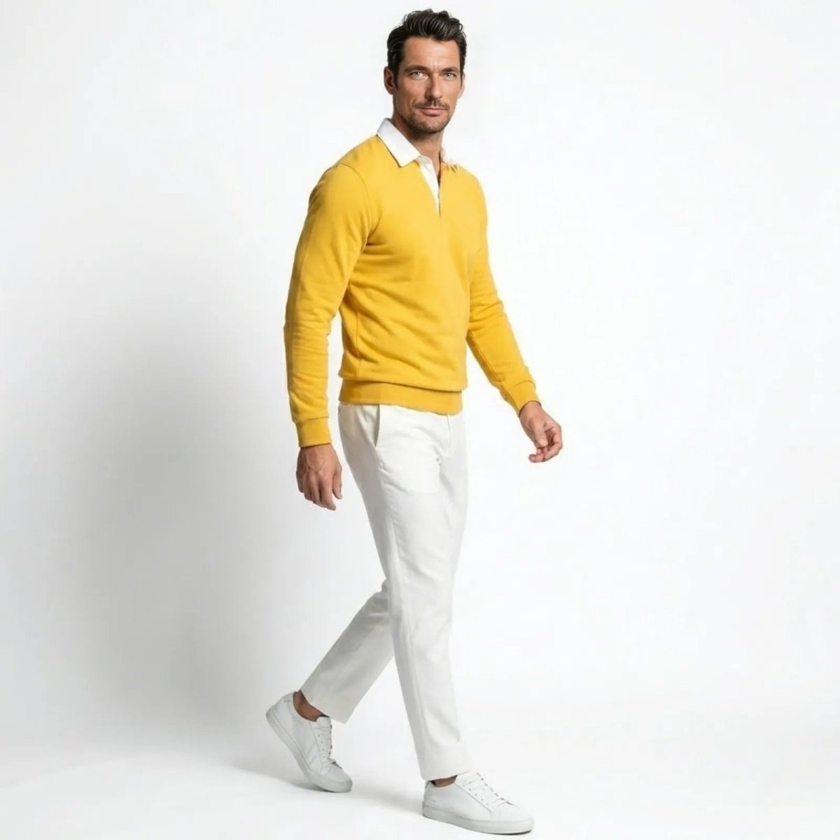 Side profile of a man walking in a yellow knit polo sweater, showing its regular fit and sleeve length.