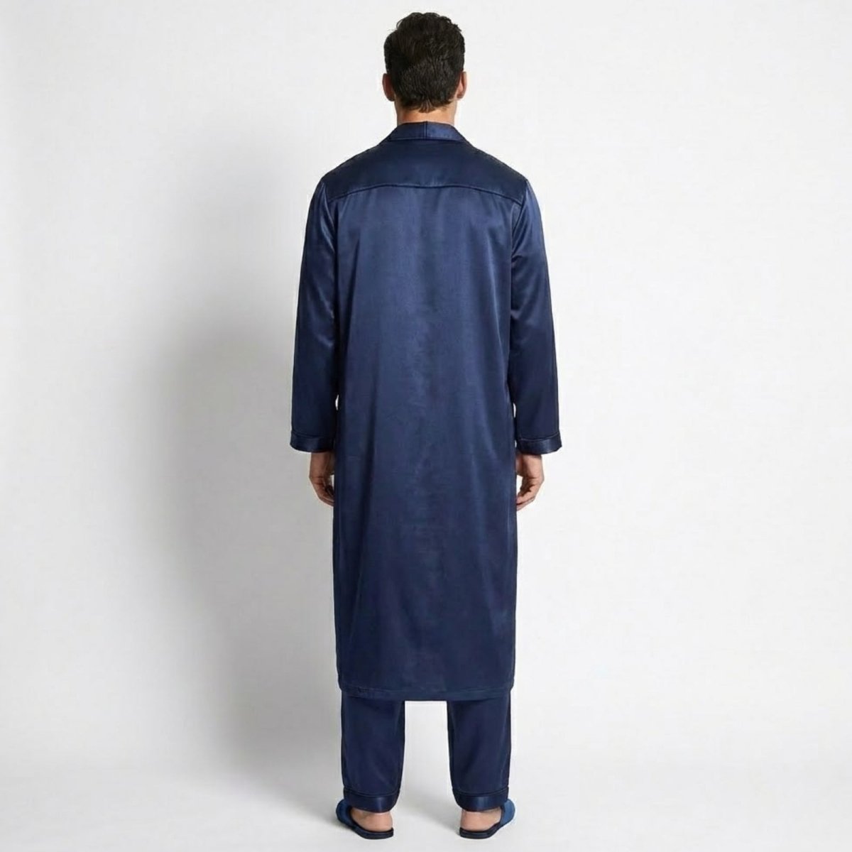 Back view of a model wearing the Kouvr navy satin long robe and pajama pants, showcasing the fit from behind.