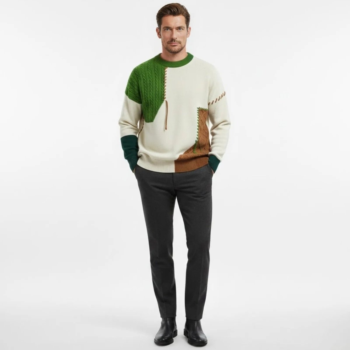 Male model wearing the Kouvr patchwork sweater in green, white, styled with dark grey trousers and black boots, against a white background.