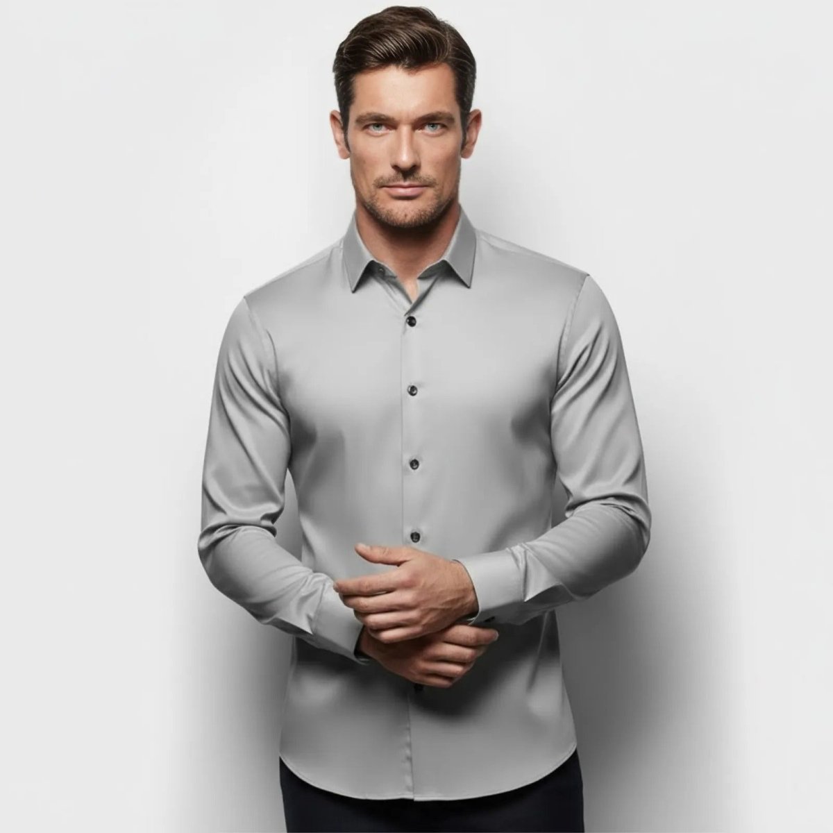Man with brown hair and blue eyes wearing the Kouvr slim fit performance dress shirt in light grey, shown from the front.