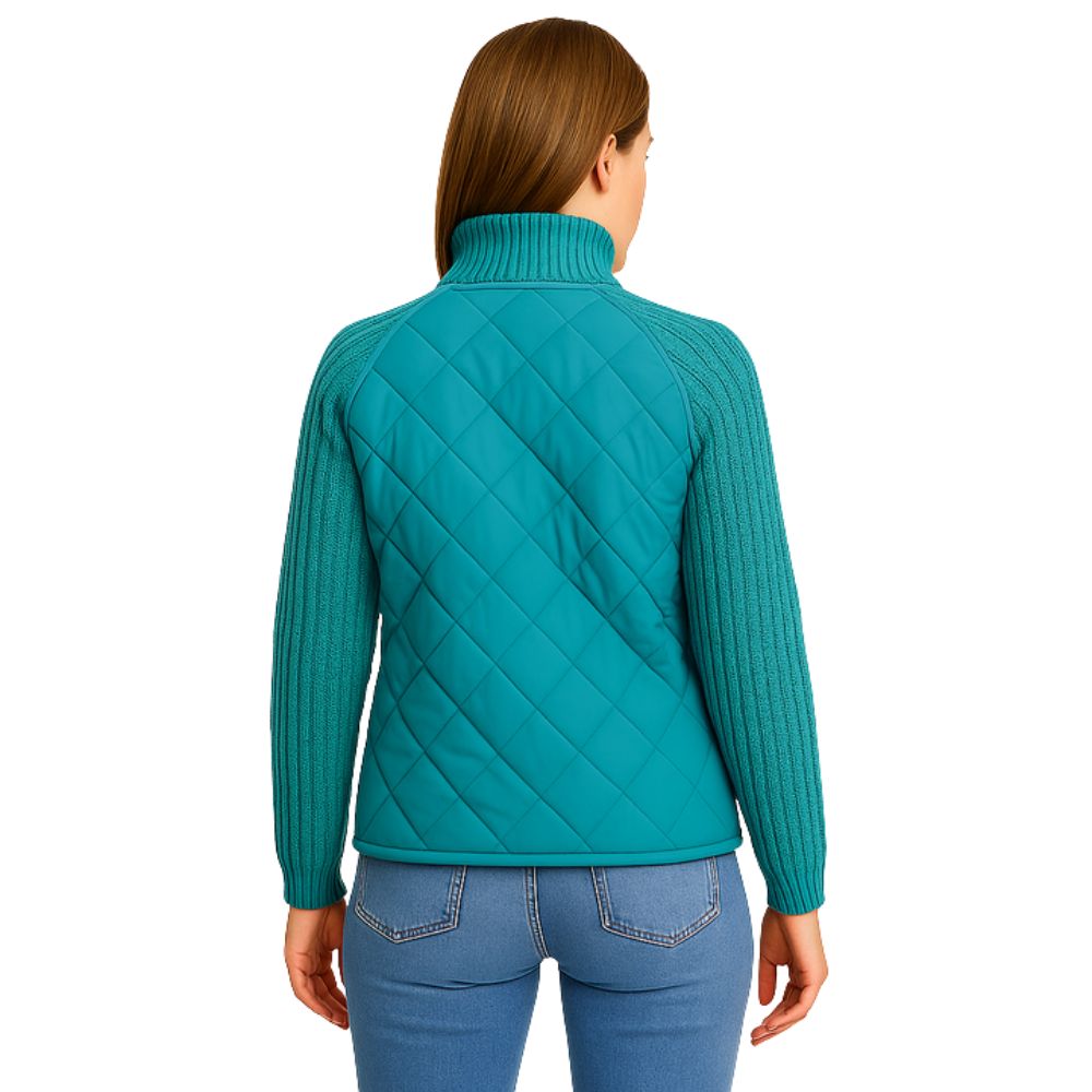 Model wearing the Kouvr Mika Hybrid Bomber Jacket in Aegean Teal, featuring cable-knit sleeves and a diamond-quilted body, paired with light-wash skinny jeans