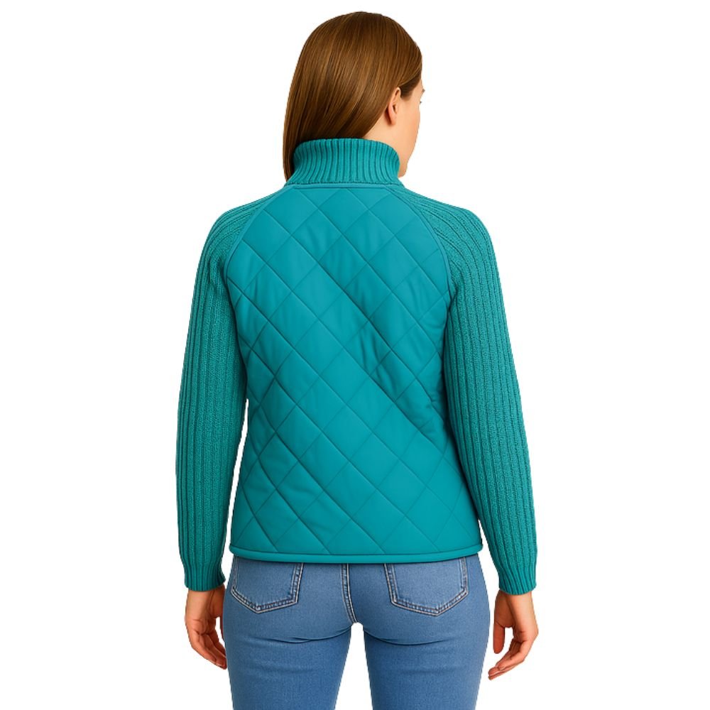 Model wearing the Kouvr Mika Hybrid Bomber Jacket in Aegean Teal, featuring cable-knit sleeves and a diamond-quilted body, paired with light-wash skinny jeans