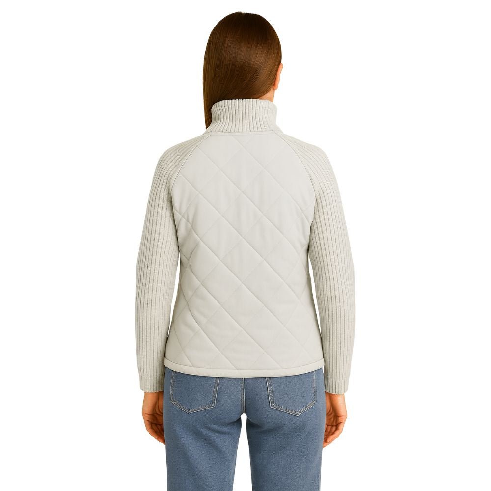 Model wearing the Kouvr Mika hybrid jacket in Heather Gray and Winter White, featuring quilted body and honeycomb knit sleeves, styled with jeans