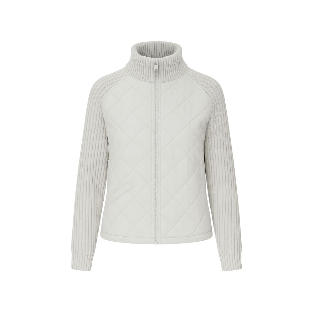 Model wearing the Kouvr Mika hybrid jacket in Heather Gray and Winter White, featuring quilted body and honeycomb knit sleeves, styled with jeans