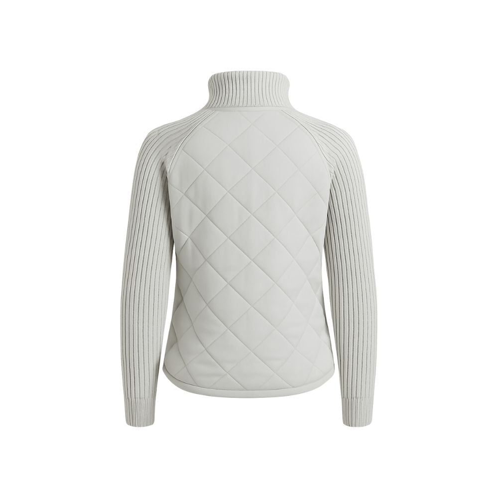 Model wearing the Kouvr Mika hybrid jacket in Heather Gray and Winter White, featuring quilted body and honeycomb knit sleeves, styled with jeans