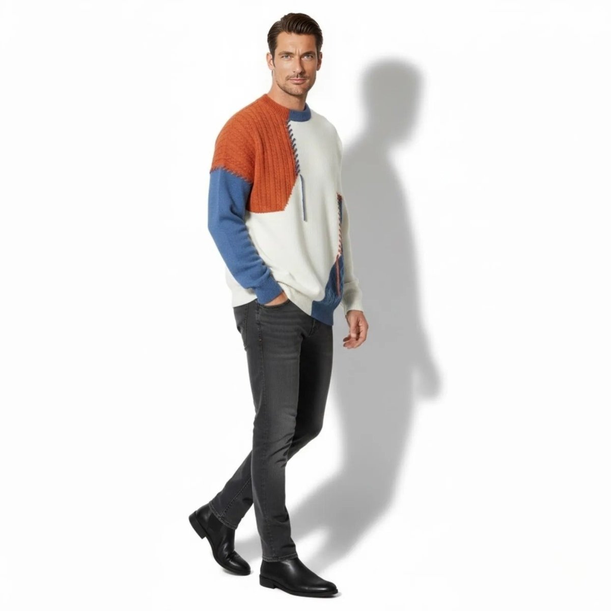 Male model in a walking pose wearing the Kouvr colorblock sweater, showing the side profile and texture of the knit against dark wash jeans.