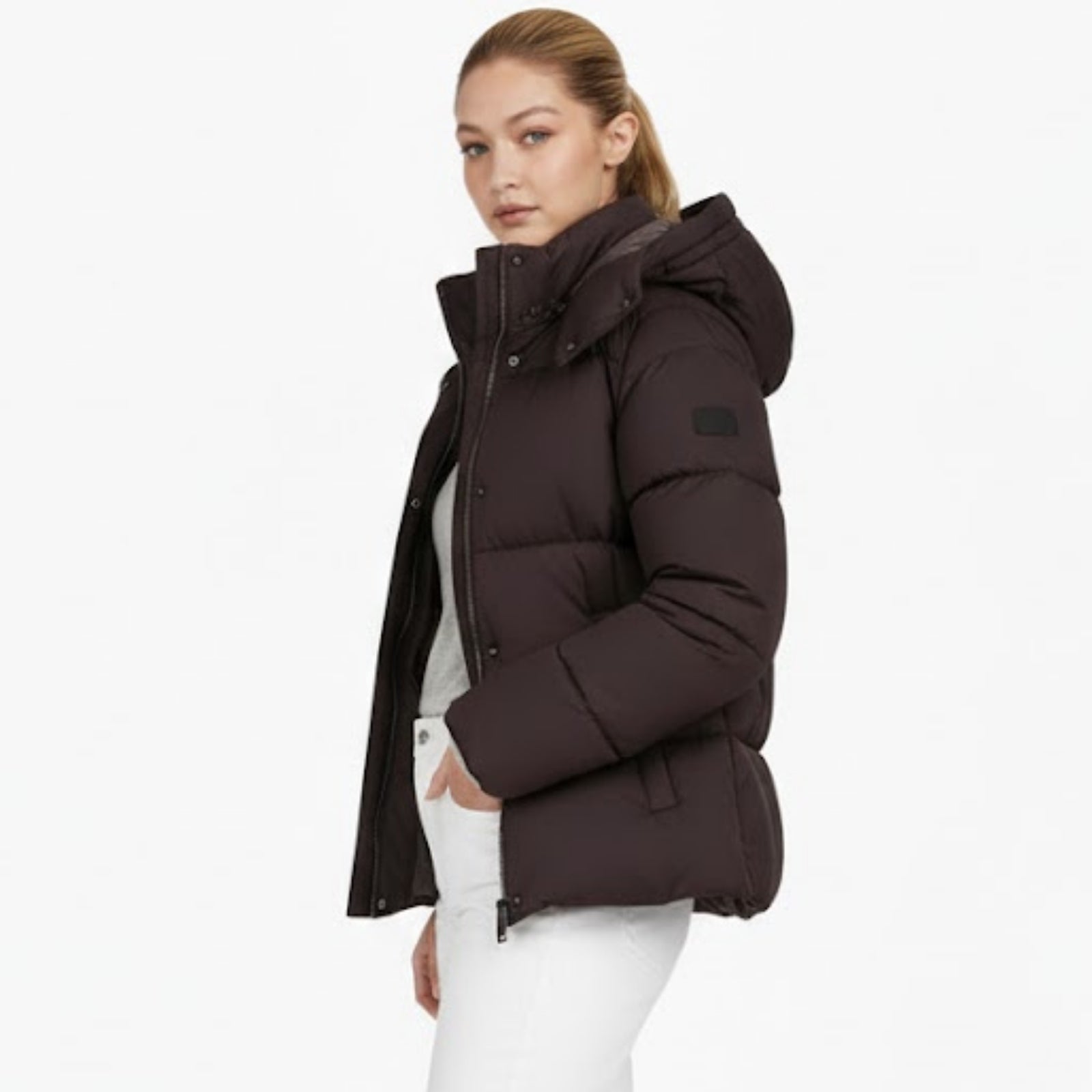 Side profile of a woman in the Kouvr Miranda puffer jacket in espresso brown, showcasing the oversized hood and silhouette.