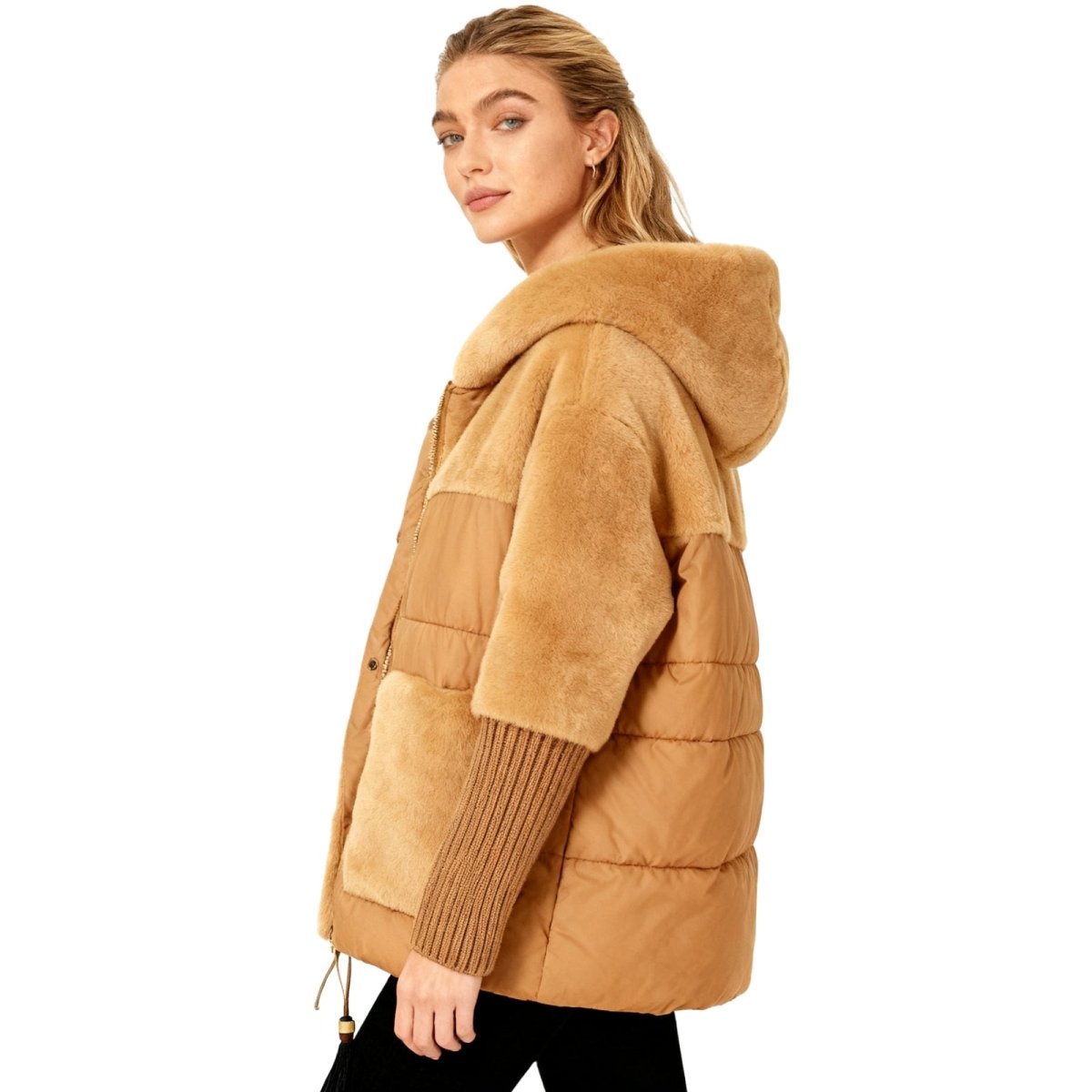 Side profile of a woman in the Kouvr deep khaki hooded puffer jacket, showing the texture of the knit cuffs and quilted body.