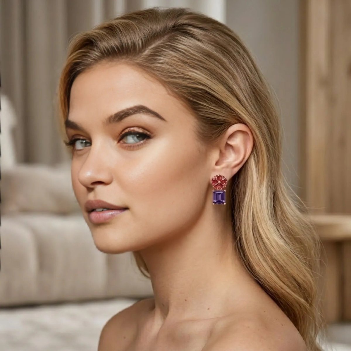 A blonde model wearing the Kouvr Octivia amethyst and garnet flower drop earrings, showcasing their size and drape.