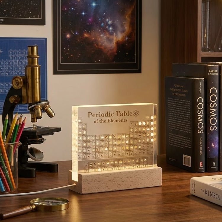 A glowing Kouvr periodic table element display on a student's desk next to "Cosmos" books and a vintage microscope.