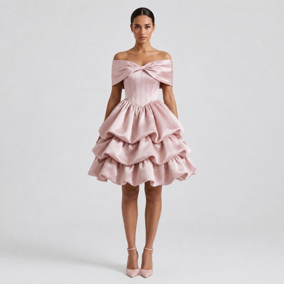 Woman wearing Kouvr pink satin off the shoulder mini dress with corset bodice and tiered ruffle skirt, front view.