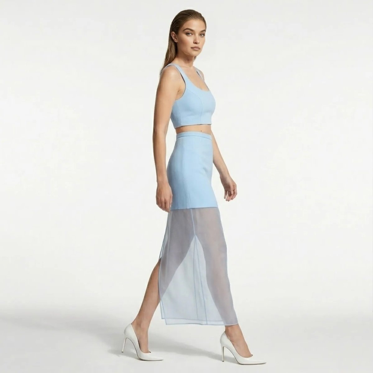 Side profile of a contemporary light blue sheer overlay maxi skirt showing fluid movement, high waist fit, and sleek styling for party events.