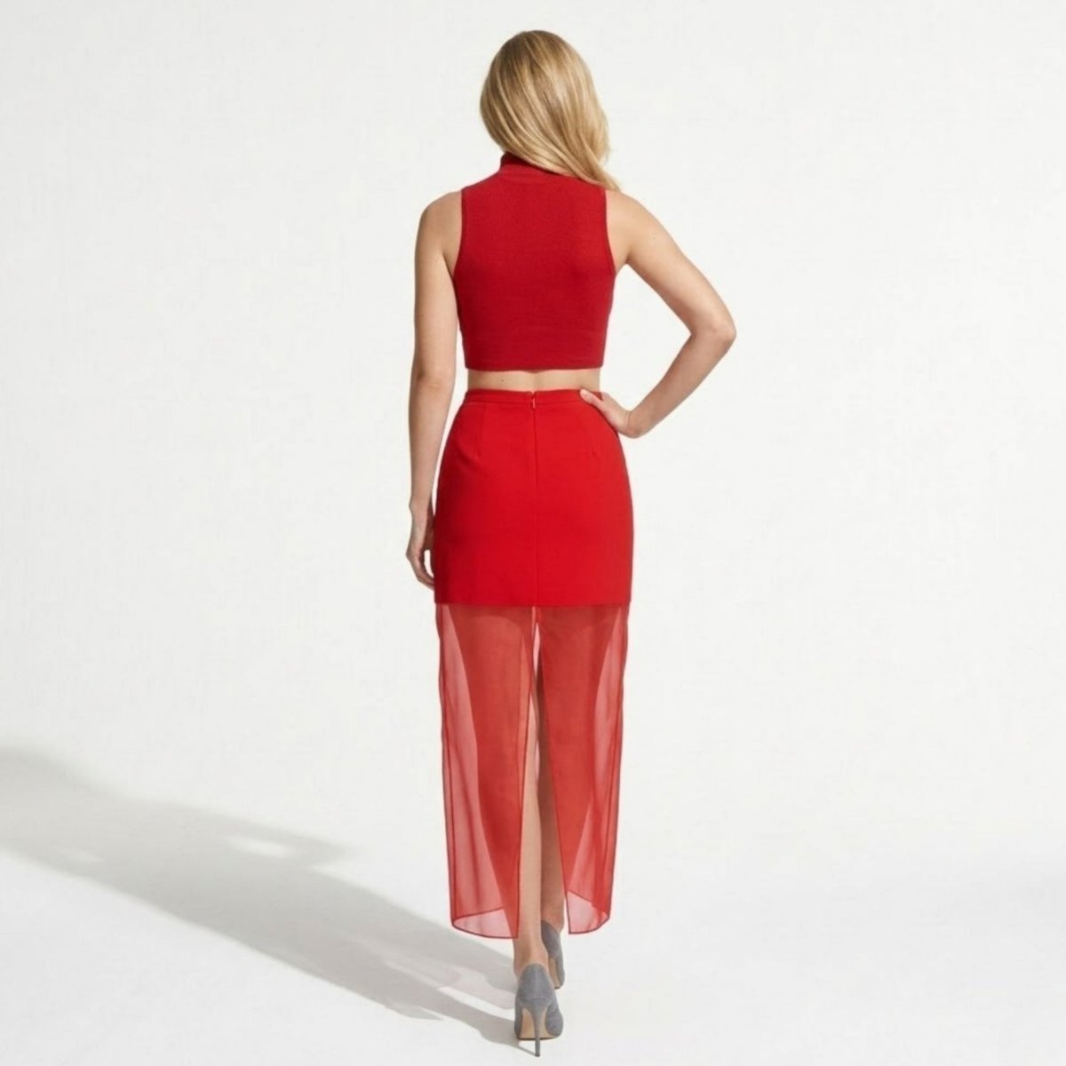 Back view of red layered skirt showing invisible zipper and back center slit on sheer fabric.