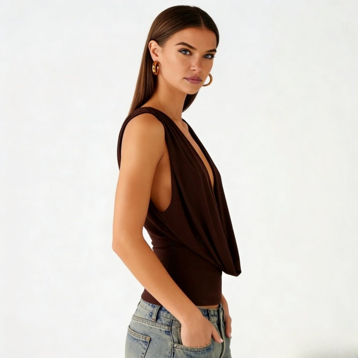 Side profile of a model in the Kouvr Rhea dark brown draped top, showing the sleeveless design and elegant fit.