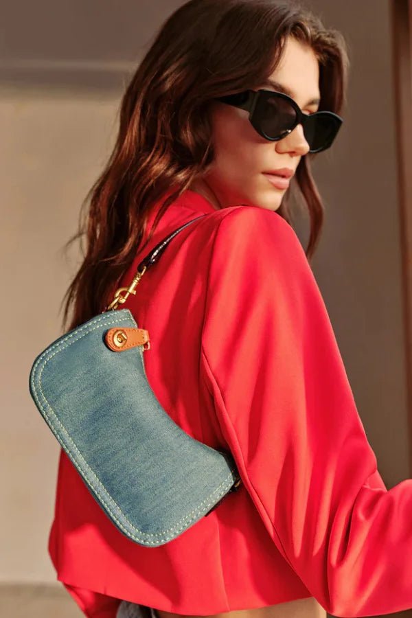 Close-up detail of the gold turn-lock clasp and contrast stitching on the Kouvr Romy denim bag.