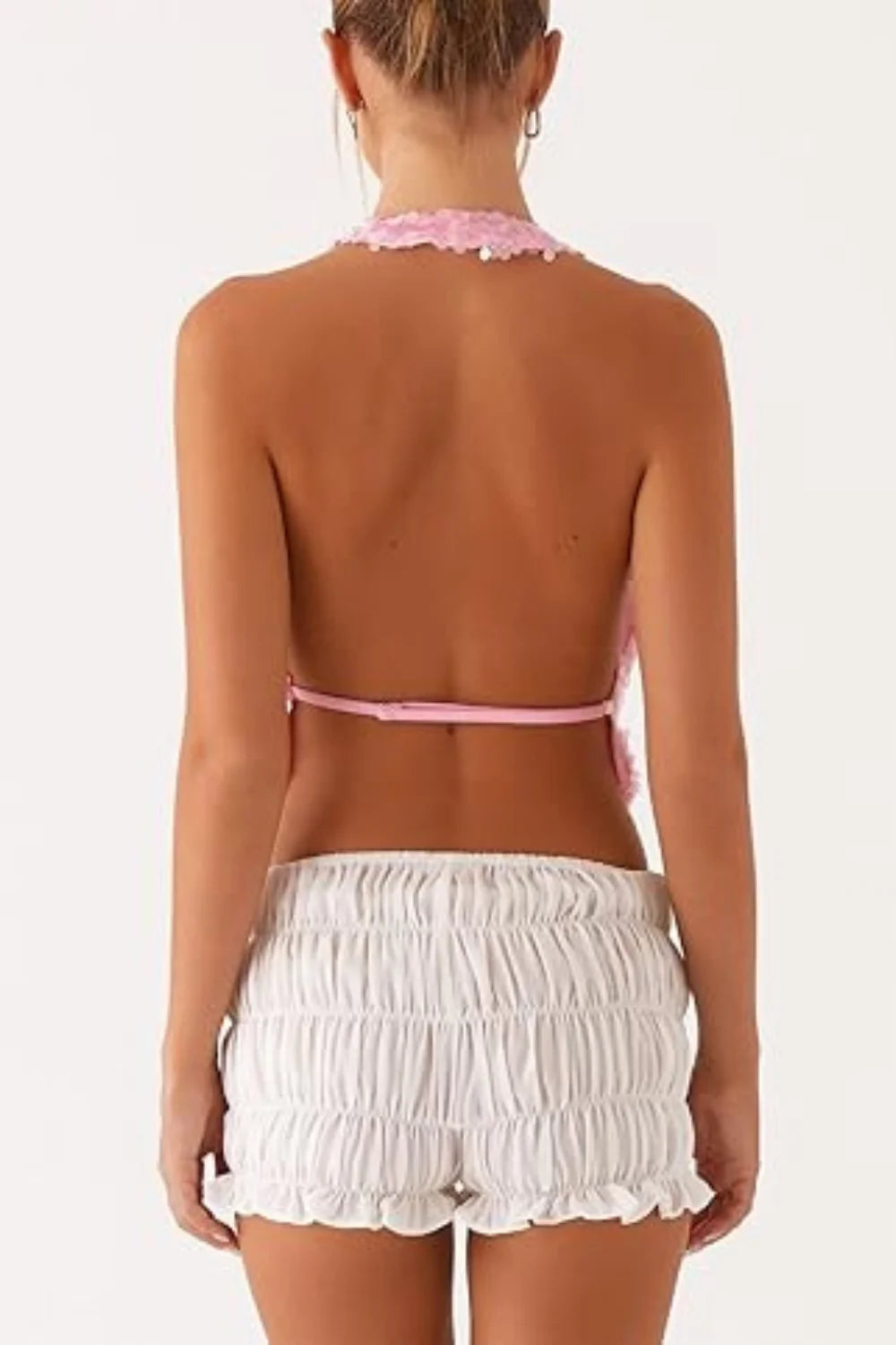 Model wearing Kouvr Fashion pink sequin backless cowl neck halter top with ruched shorts