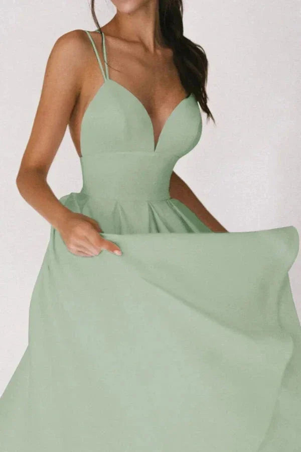 Model from behind showing the crisscross spaghetti straps on the Kouvr sage green A-line dress