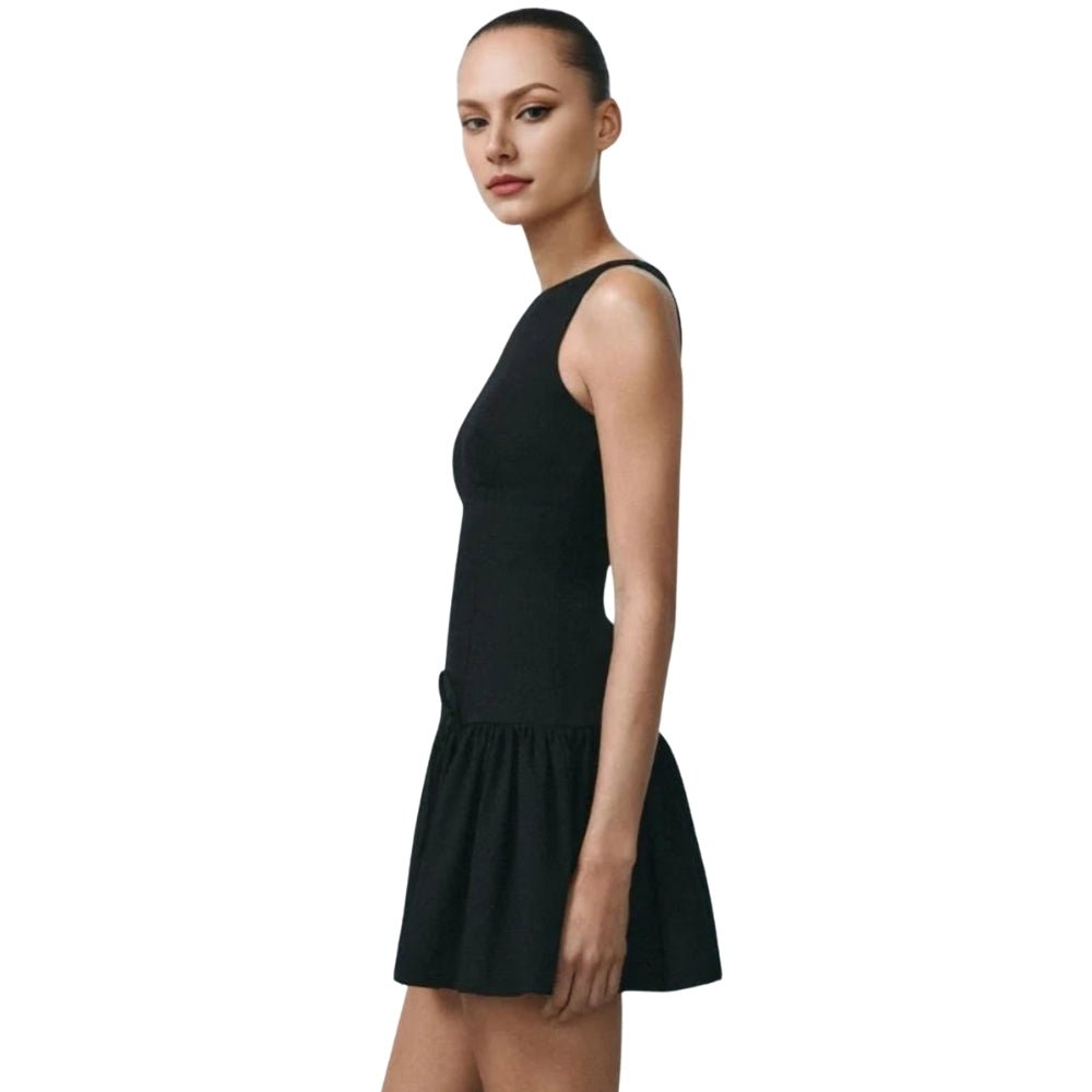 Woman wearing a black Kouvr sleeveless dress on a white background