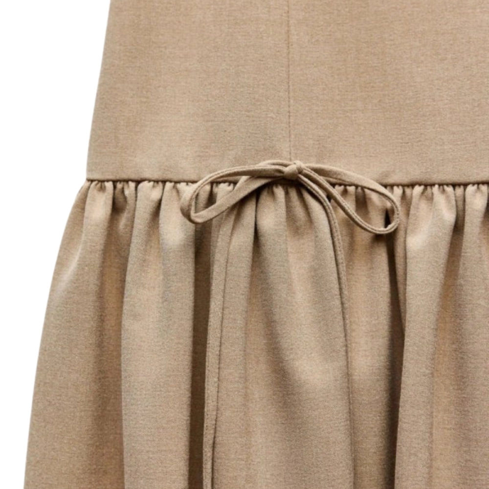 Close-up of a  khaki Kouvr skirt with a tie waist on a white background