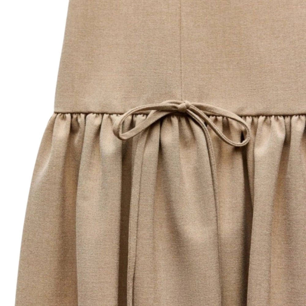 Close-up of a  khaki Kouvr skirt with a tie waist on a white background