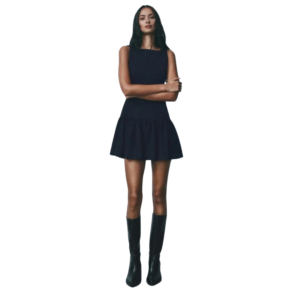 Woman wearing a Navy Kouvr dress and black boots on a white background