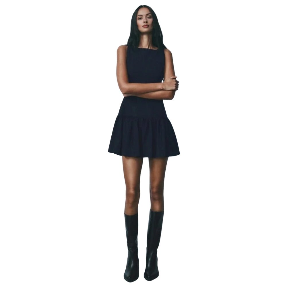 Woman wearing a Navy Kouvr dress and black boots on a white background