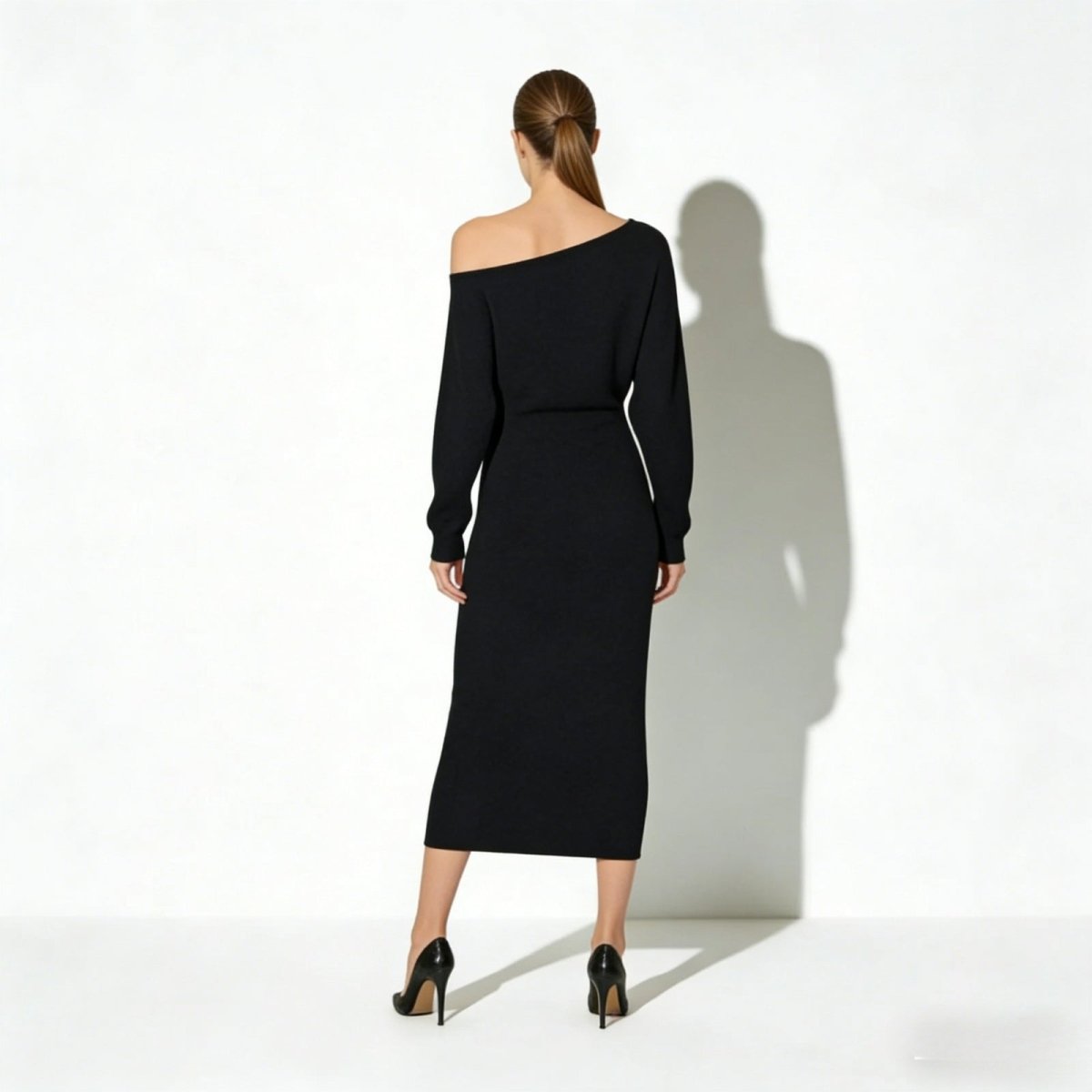 Back view of the Kouvr Selena asymmetrical black midi dress showcasing its elegant neckline.