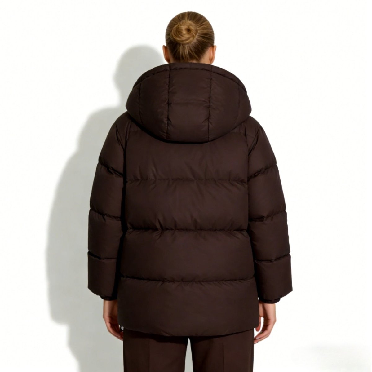 Back view of the Kouvr Sheena insulated winter coat in dark brown, highlighting the oversized hood and clean silhouette.