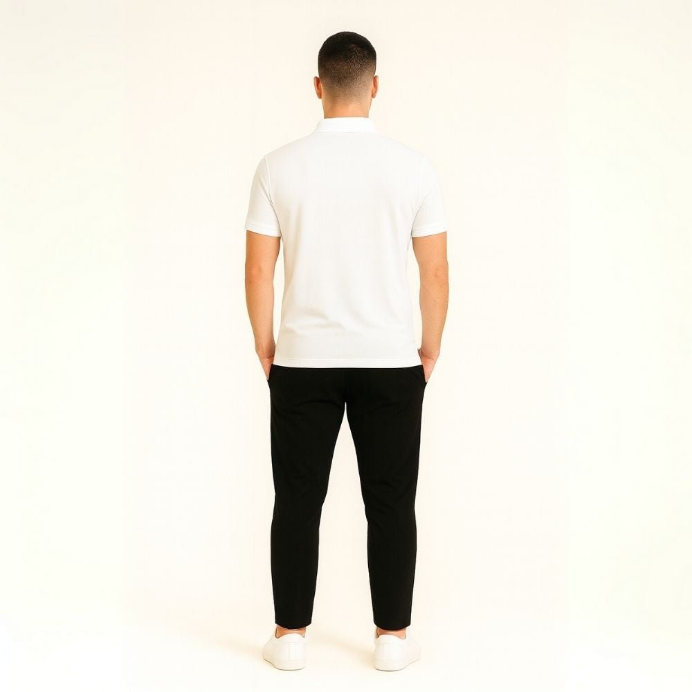 Person wearing a white kouvr t-shirt and black pants on a plain background