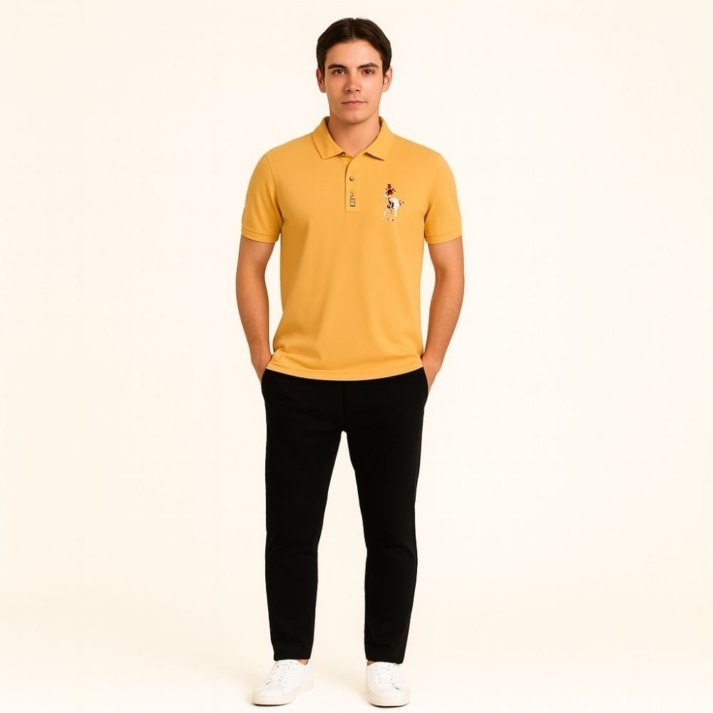 Man wearing a yellow kouvr polo shirt with a logo on a beige background