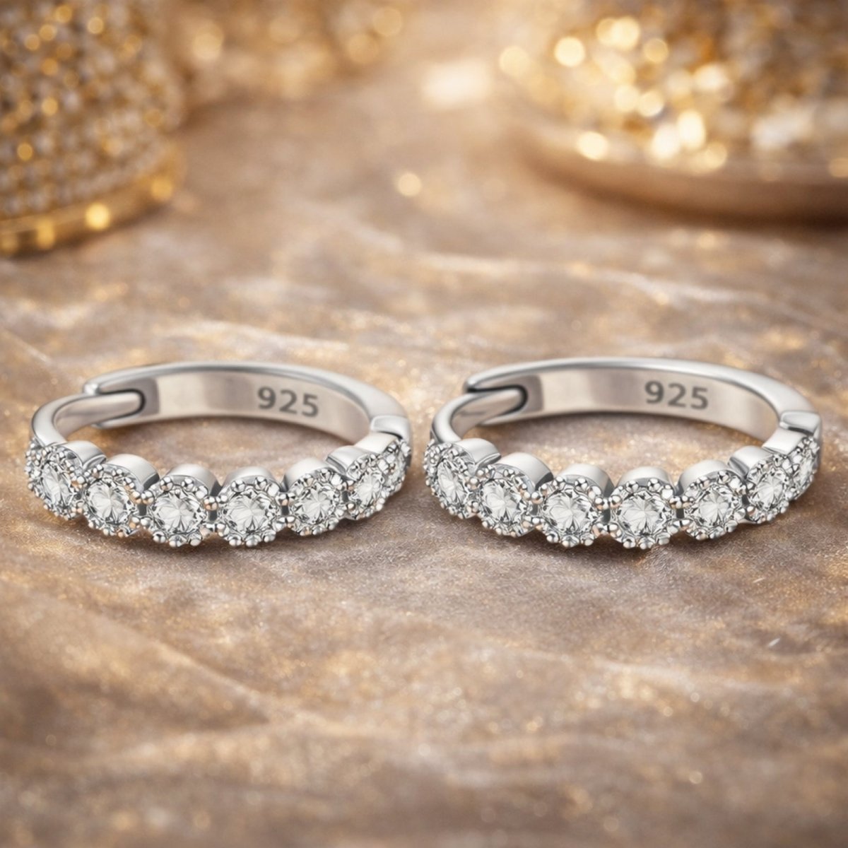 A pair of Kouvr sterling silver diamond huggie earrings in a jewelry box with a measurement overlay indicating their 1.3cm (0.51in) diameter.