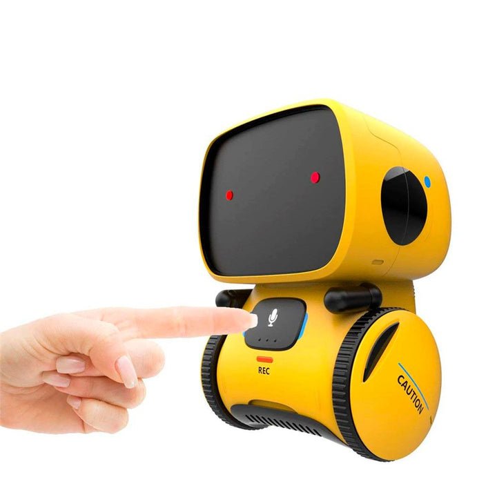 A child's finger touching the microphone button on the yellow Kouvr robot to demonstrate its touch control feature.